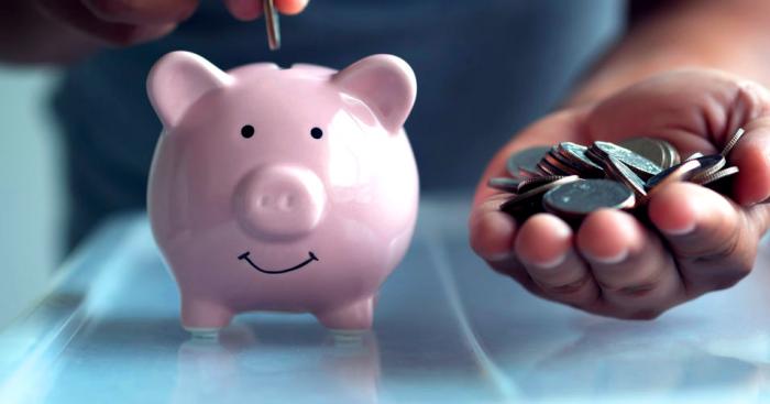 Putting coins into piggy bank retirement plan Putting coins into piggy bank retirement plan